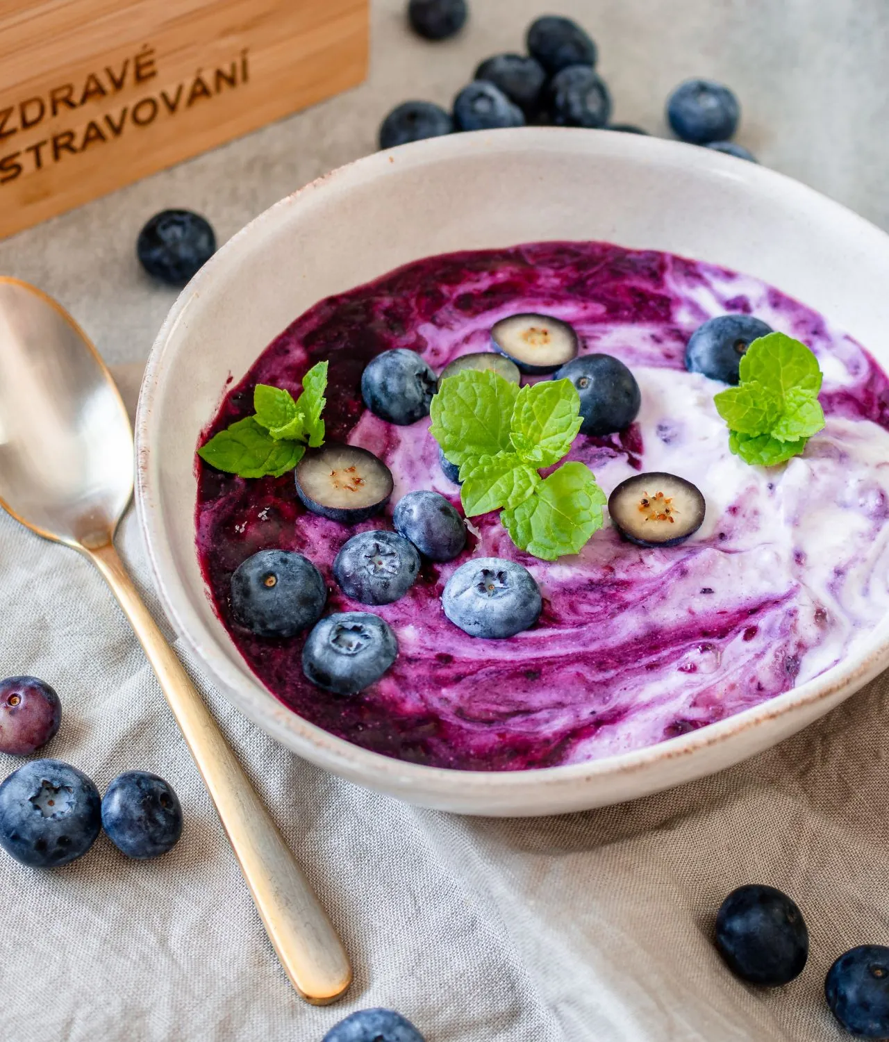 A bowl of blueberry cream with fresh blueberries and mint