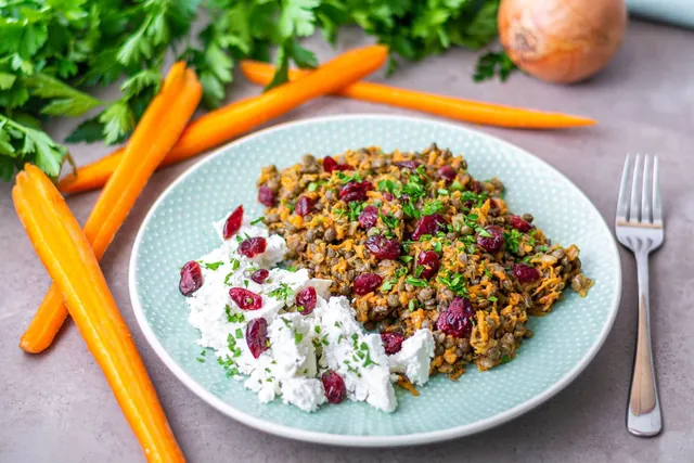 A plate of lentil salad with goat cheese, cranberries and carrot