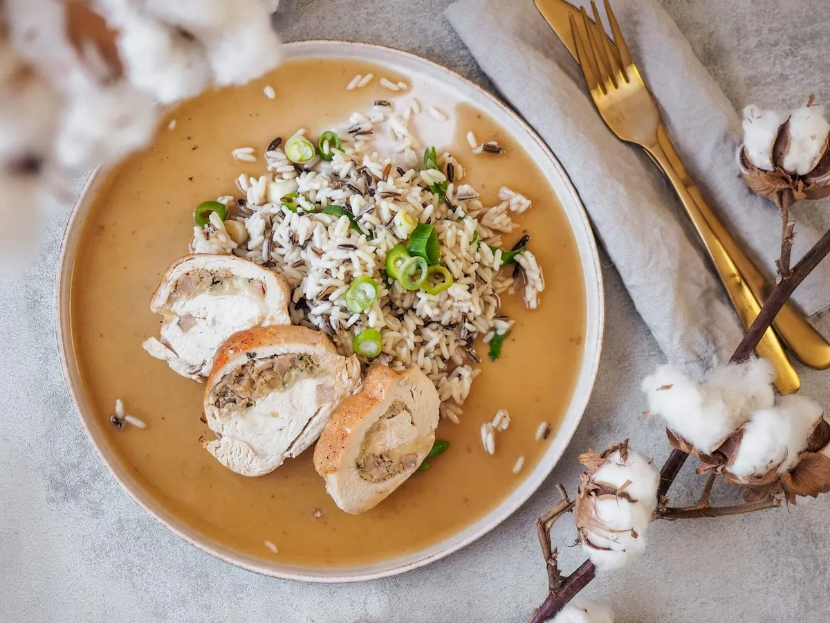 A plate of poultry roulade with wild rice and sauce