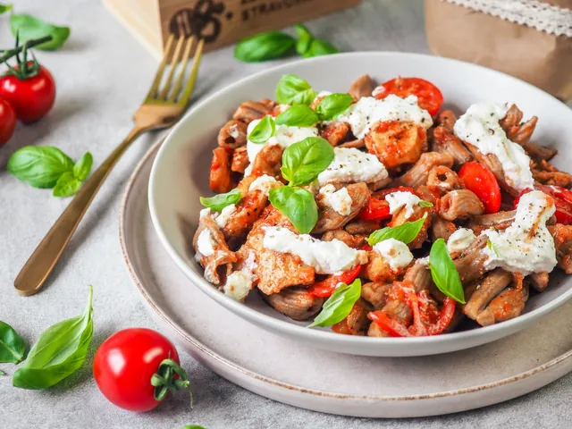 A bowl of wholegrain pasta with chicken, ricotta and tomatoes